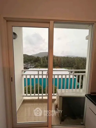 Charming balcony view with lush greenery and distant hills, perfect for relaxation and enjoying nature.