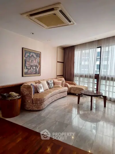 Spacious living room with elegant sofa and large window for natural light.