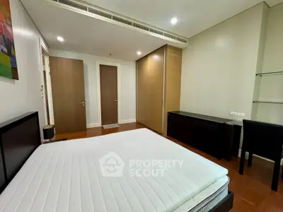Spacious bedroom with modern furnishings and ample storage in a stylish apartment.