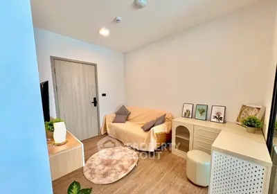 Cozy living room with modern decor and wooden flooring, featuring a comfortable sofa and stylish accents.