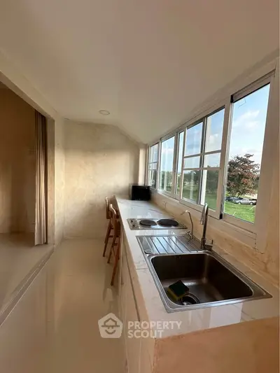 Bright kitchen with sleek countertops and scenic window view