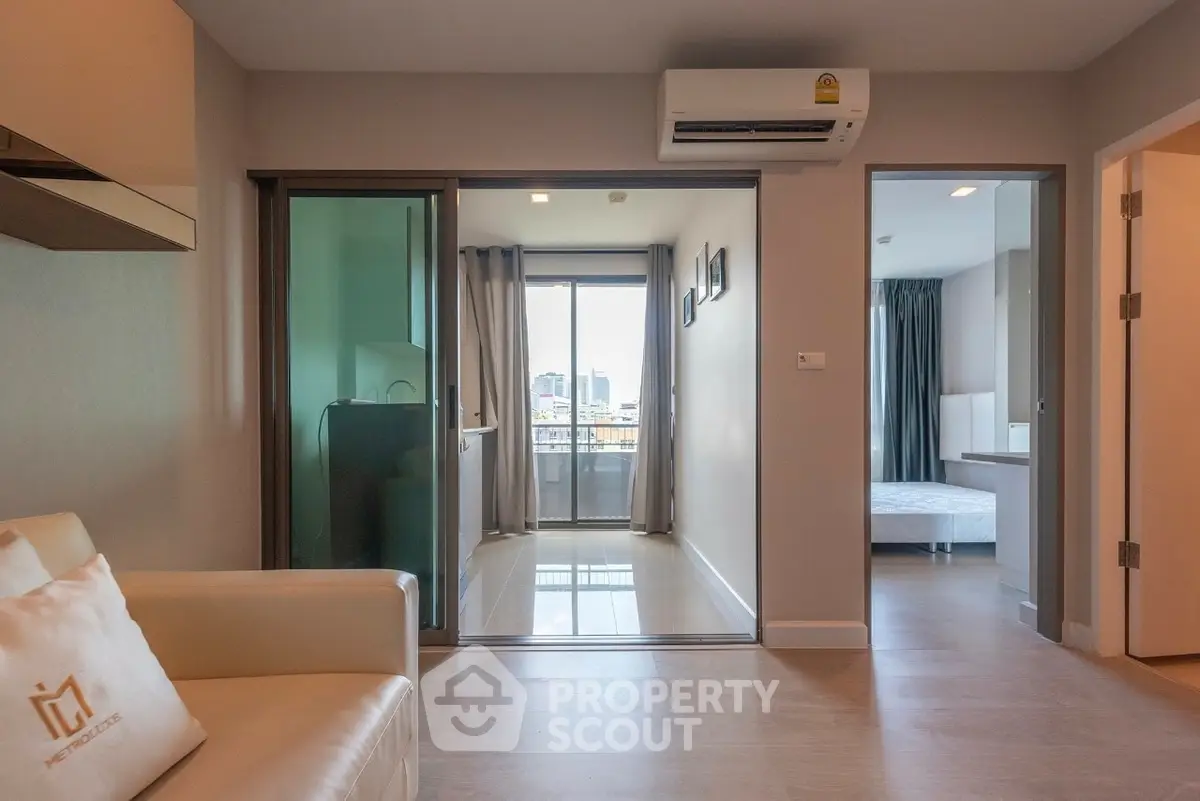 Modern apartment interior with balcony view, featuring sleek design and natural light.