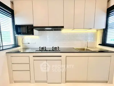 Modern kitchen with sleek cabinets and gas stove in bright apartment