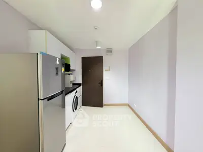 Modern kitchen with sleek appliances and minimalist design in a compact space.