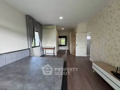 Spacious bedroom with modern decor and large windows for natural light.