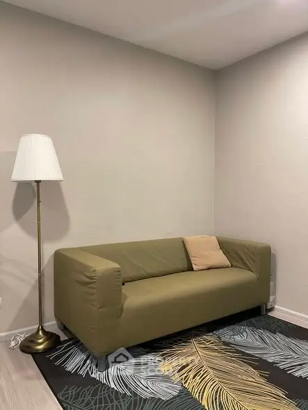 Modern living room with olive green sofa and stylish floor lamp.