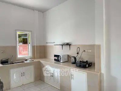 Cozy kitchen with gas stove and microwave in a bright, tiled space.