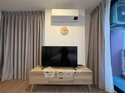 Modern living room with sleek TV stand, air conditioning, and elegant curtains