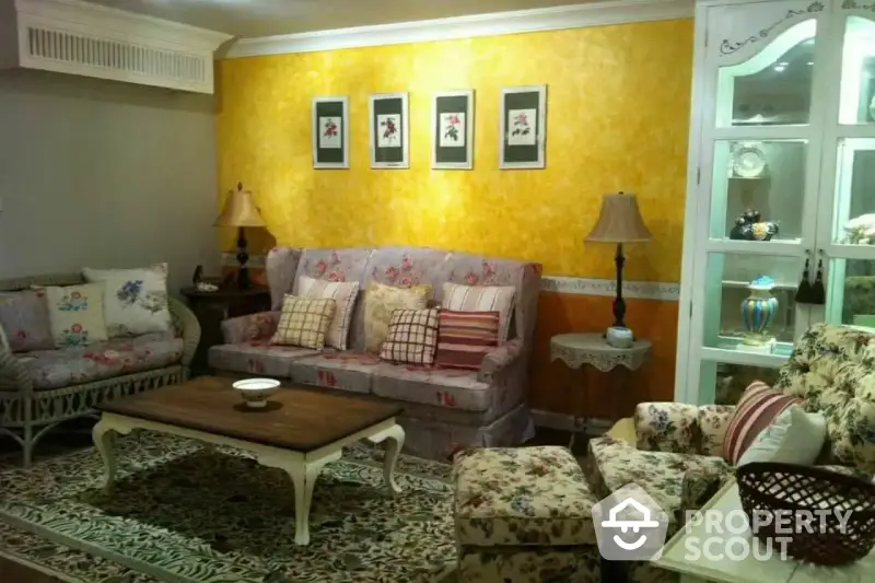 Charming living room with vibrant yellow walls, cozy patterned sofas, and classic wooden furniture, creating a warm, inviting atmosphere.