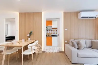 Modern living room with dining area and view into a stylish kitchen, featuring wood accents and bright decor.