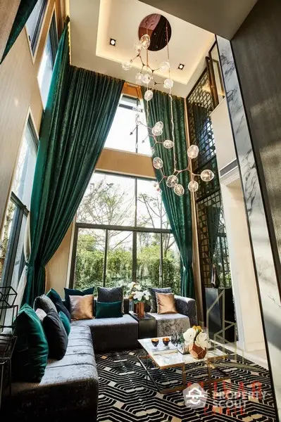 Luxurious high-ceiling living room with elegant drapery, modern furniture, and a stunning glass chandelier, complemented by natural light from large windows.