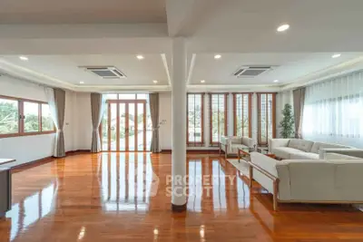 Spacious and elegant living room with large windows and polished wooden floors.