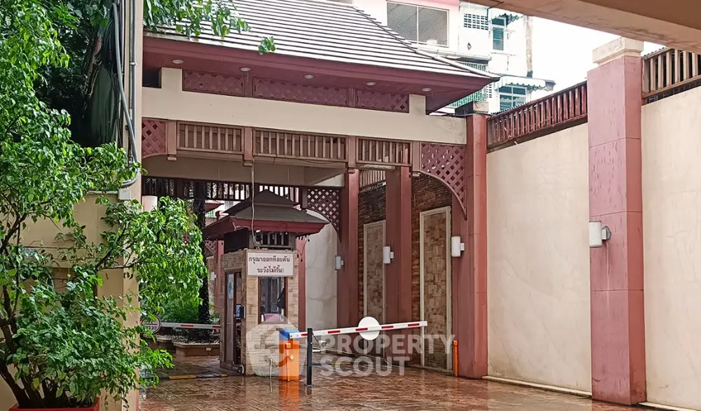 Charming gated entrance with lush greenery and traditional architectural elements