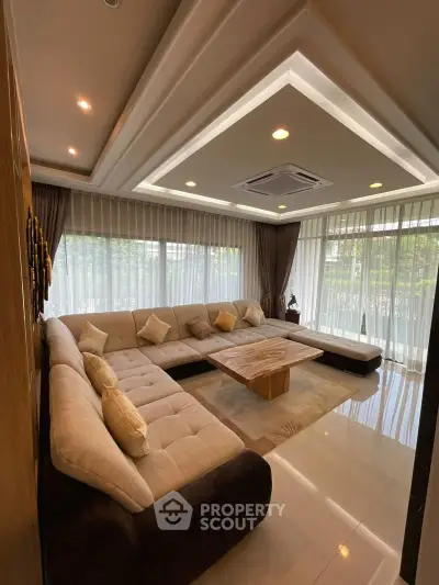 Luxurious living room with large sectional sofa and elegant ceiling design