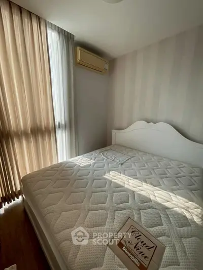 Cozy bedroom with natural light and elegant decor, featuring a comfortable bed and stylish air conditioning unit.