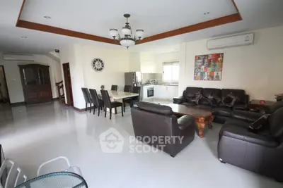Spacious open-plan living room with modern furniture and dining area in a stylish apartment.