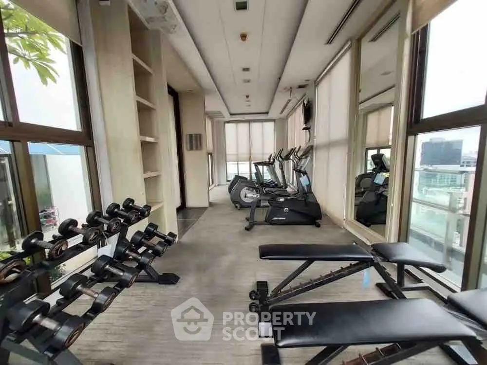 Luxurious gym with modern equipment and city view in high-rise building