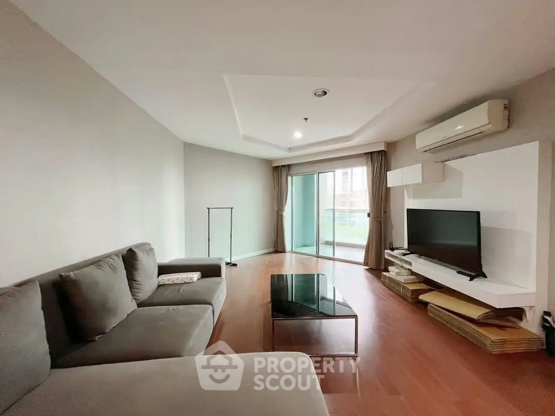 Spacious living room with modern decor and large windows in a stylish apartment.