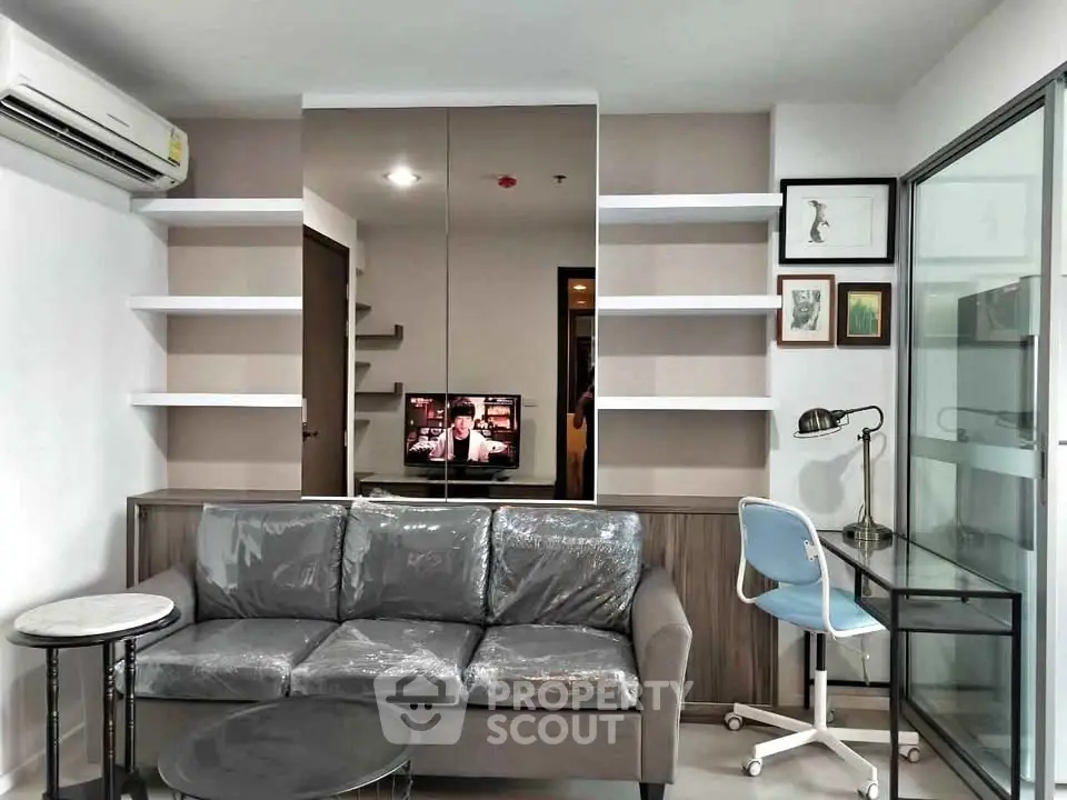Modern living room with sleek furniture and stylish decor, featuring a comfortable sofa and a work desk.