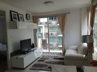 Bright and cozy living room with modern decor and balcony view in urban apartment.
