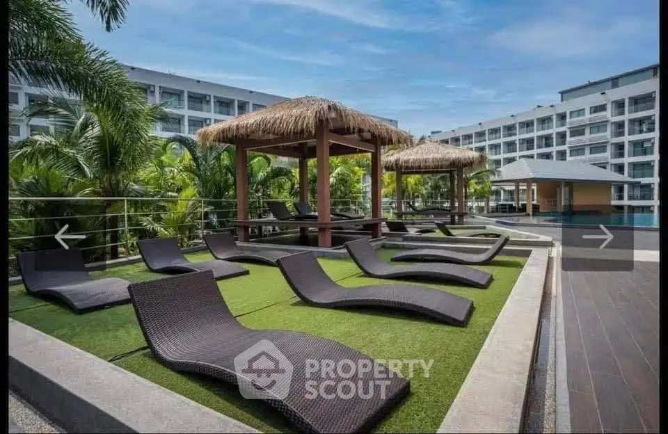 Luxurious resort-style pool area with sun loungers and tropical cabanas, perfect for relaxation and leisure.