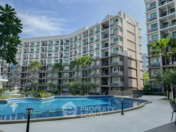 Luxurious condominium with a stunning pool and lush greenery, perfect for modern living.