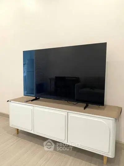 Modern living room with sleek TV on stylish console, perfect for entertainment.
