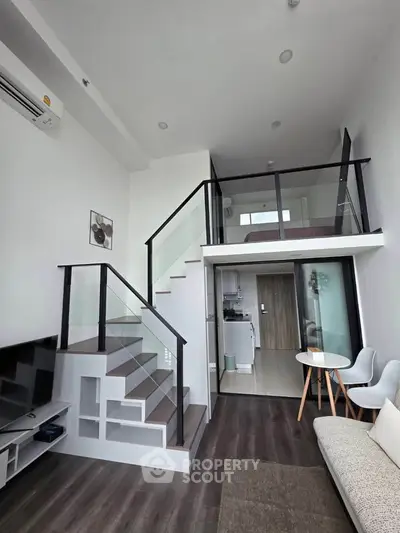 Modern loft apartment with stylish staircase and open living area, featuring sleek design and ample natural light.