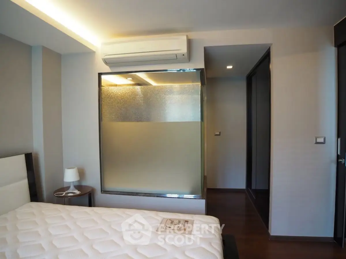 Modern bedroom with air conditioning and stylish frosted glass partition.