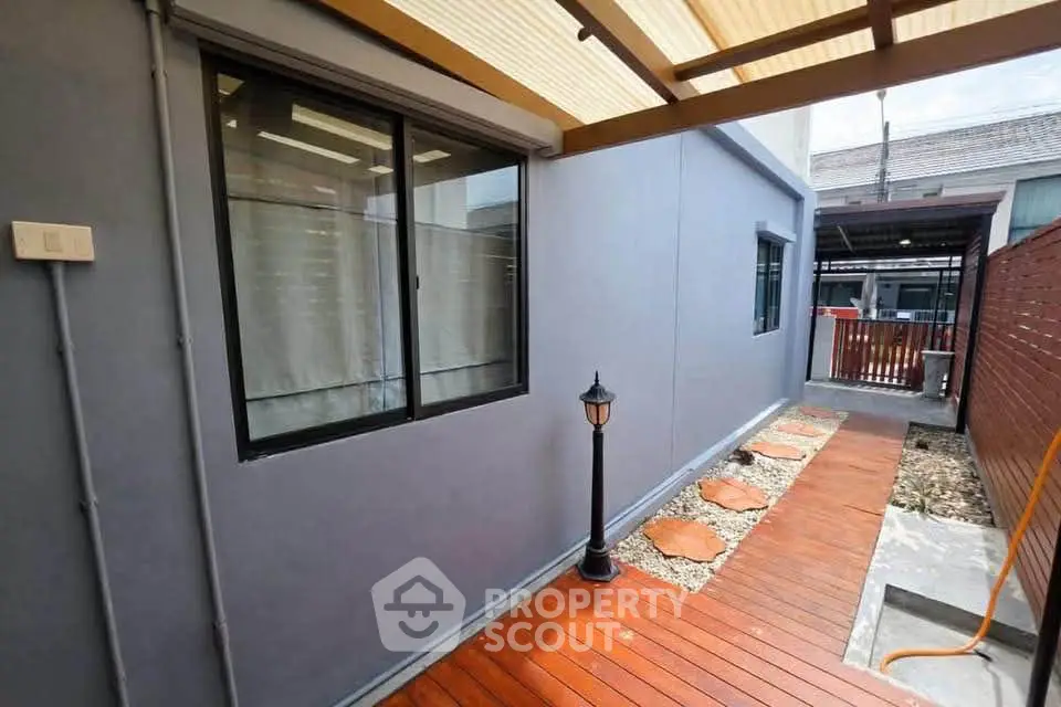 Modern exterior walkway with wooden deck and stylish lighting