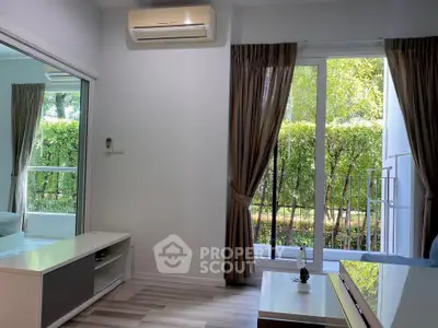 Modern living room with large window and garden view, featuring air conditioning and stylish decor.