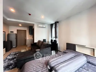 Modern studio apartment with sleek furnishings and open layout, featuring a cozy living area and compact kitchen.