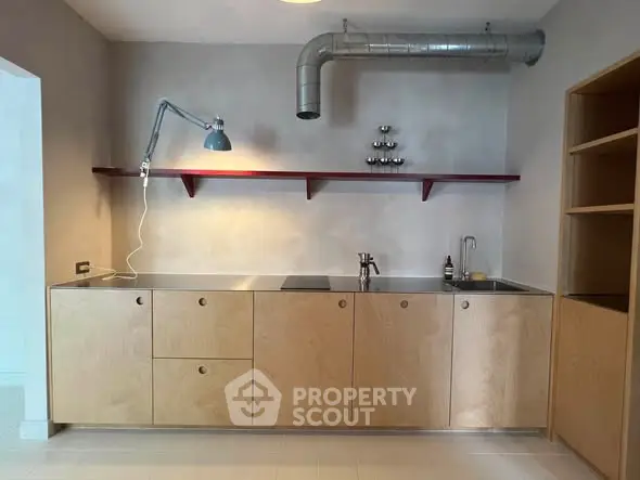 Modern minimalist kitchen with sleek cabinetry and industrial lighting