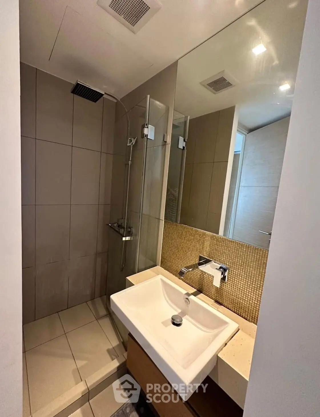 Modern bathroom with sleek shower and stylish sink in a contemporary apartment.