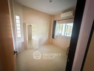 Spacious bedroom with air conditioning and large window for natural light.