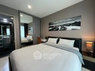 Modern bedroom with stylish decor and mirrored closet doors in a cozy apartment.
