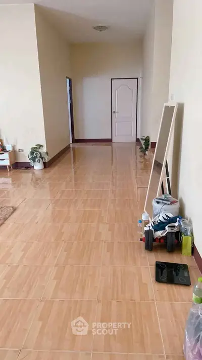 Spacious hallway with tiled flooring and modern decor in a residential property.