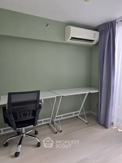 Modern study room with sleek desk, ergonomic chair, and air conditioning in a bright apartment.