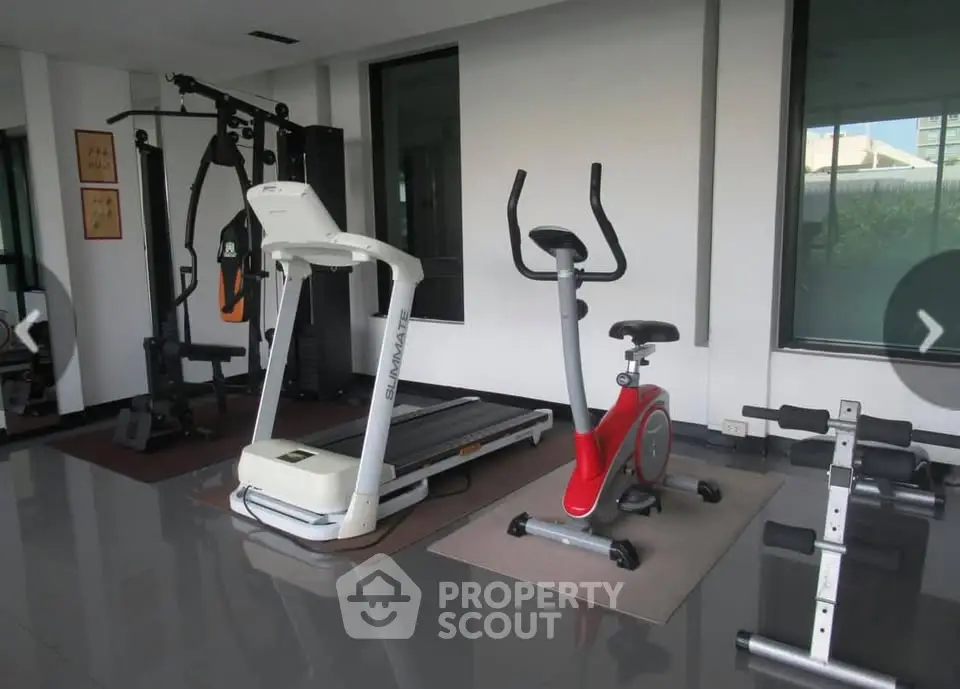 Modern gym with treadmill, exercise bike, and weight equipment in a bright, spacious room.