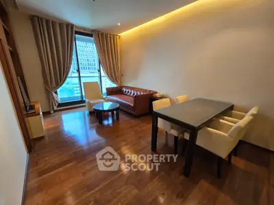 Spacious living room with elegant hardwood floors and modern furniture in a high-rise apartment.