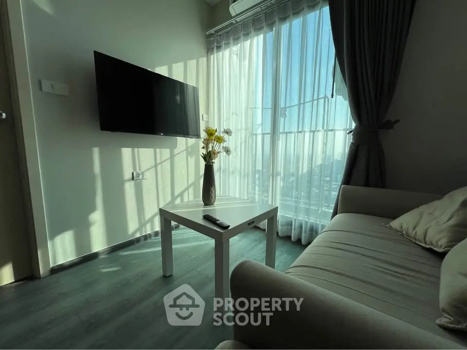 Cozy living room with modern decor and large window offering natural light and scenic views.