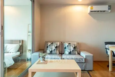 Modern living room with cozy sofa and air conditioning, adjacent to a stylish bedroom.