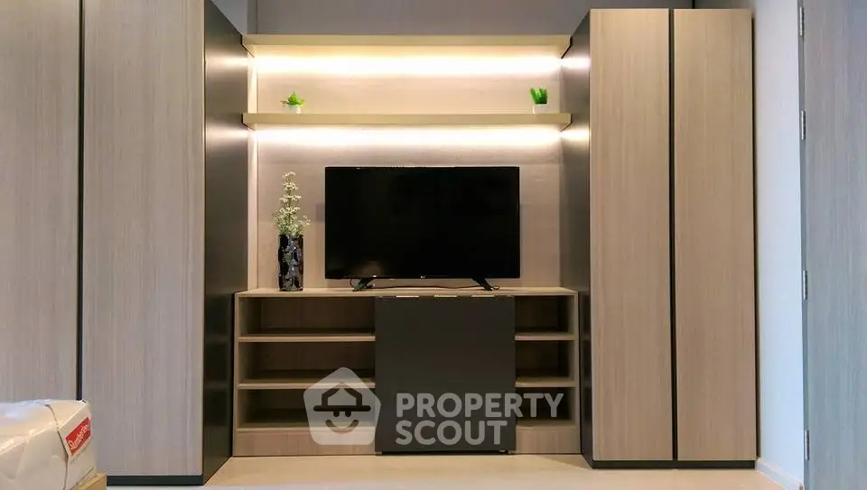 Modern living room with sleek wooden cabinetry and flat-screen TV, perfect for stylish urban living.