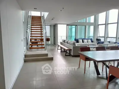 Luxurious modern living room with floor-to-ceiling windows and elegant staircase in a high-rise apartment.