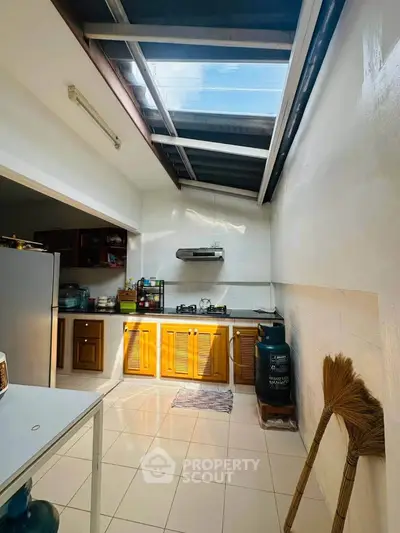 Bright kitchen with skylight and gas stove, featuring wooden cabinets and modern appliances.