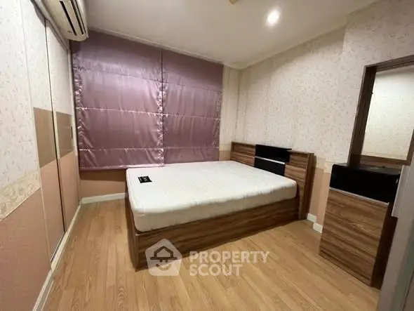 Cozy bedroom with modern design and wooden flooring, featuring a comfortable bed and stylish decor.
