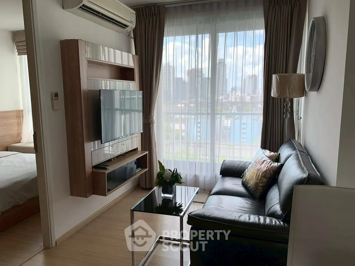 Modern living room with city view, featuring sleek furniture and large windows for natural light.