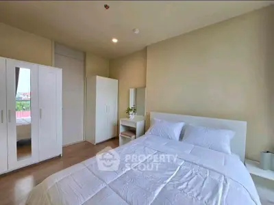 Spacious bedroom with modern white furniture and natural light