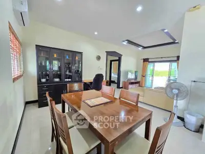 Spacious dining area with elegant wooden furniture and natural light, perfect for family gatherings.