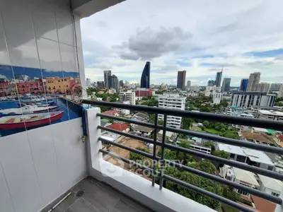 Stunning cityscape view from a high-rise balcony with modern railing and vibrant wall art.